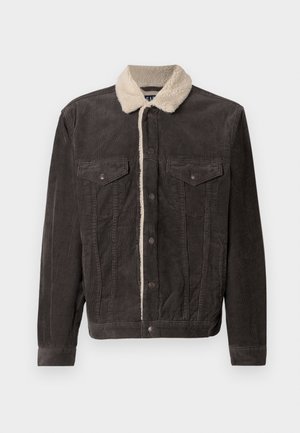 Dark gray corduroy jacket with a cream faux fur collar, featuring two chest pockets and front metal snap buttons. Textured fabric with vertical lines.