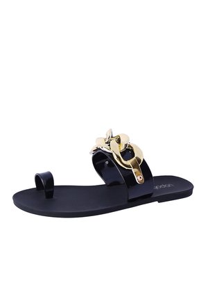 Sandalia plana negra con acento floral dorado, hecha de material brillante. Cuenta con un bucle para el dedo del pie y una suela suave. Diseño minimalista.