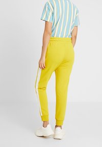 Puma Pantalones deportivos - mustard yellow