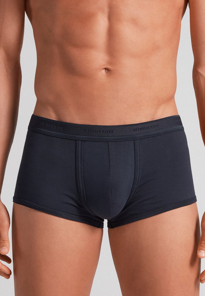 Bóxer azul oscuro hecho de una tela suave y elástica. Presenta una cinturilla con el logo de la marca y un diseño ajustado con costuras mínimas.