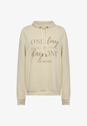 Krém színű pulóver, galléros, zsinóros, hosszú ujjakból, nyomtatott szöveggel: "Egy nap vagy az első nap, te döntesz."