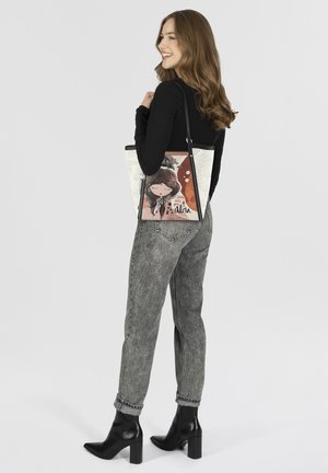 Tote bag features a black and white design with a colorful illustration of a girl. The bag has a mix of textures and a shoulder strap.