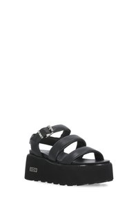 Sandali platform neri con tre ampie cinghie in pelle e una fibbia in argento. Suola in gomma testurizzata con leggere scanalature per una presa migliore.