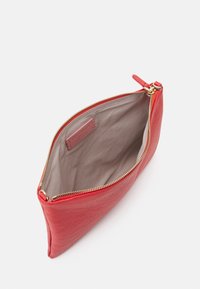 Rød læderpung med en guld lynlås lukning. Indvendigt er der beige stof med en mærkeetiket. Har en glat tekstur og slankt design.