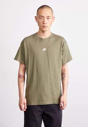 Tricou din bumbac de culoare verde măsliniu, cu o croială lejeră, având un logo Nike alb pe piept. Mâneci scurte și gât standard.