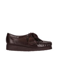 Donkerbruine leren moccasin-schoen met een crepe-zool, decoratieve strik en een gekruiste tongdetail.