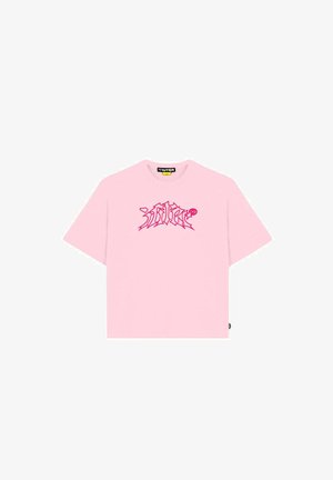 Maglietta a maniche corte di colore rosa chiaro con testo grafico astratto rosso al centro del petto e un'etichetta nera all'interno del colletto.