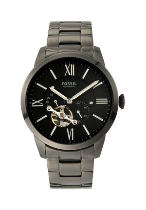 Svart Fossil automatisk armbåndsur med sølvfargede romertall, sølvfargede visere, eksponert tannhjul ved kl. 8 og metall lenke.