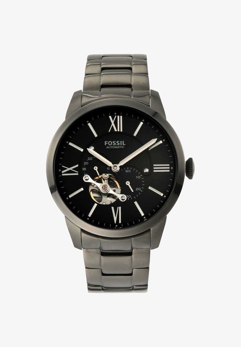 Schwarze automatische Fossil-Armbanduhr mit silbernen römischen Ziffern, silbernen Zeigern, sichtbarem Zahnrad bei 8 Uhr und Metallglied-Armband.