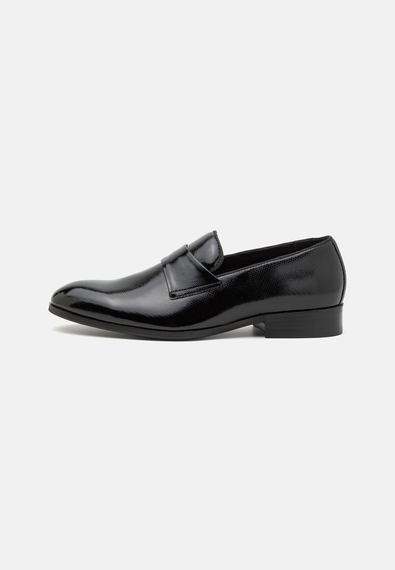 Pantofii loafer din piele neagră au o finisare netedă și lucioasă, cu un model texturat subtil pe partea superioară. Tocul este jos și robust, iar forma vârfului este rotunjită.