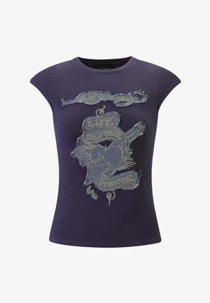 Ciemnofioletowy, dopasowany t-shirt z postrzępionymi naszywkami z dżinsu, złotym przeszyciem i napisem "Life Before Honor" nad grafiką serca i wstęgi.