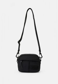 Lille sort crossbody-taske med justerbar rem, lynlåslomme foran og præget HUGO-logo-patch.