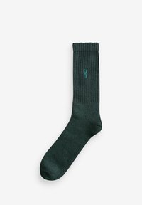 Grüne gerippte Socke aus weichem Material. Verfügt über einen glatten Zehenbereich und ein gesticktes Logo nahe dem Bund.
