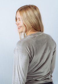 Grijs, langärmelig shirt in een zachte, gestructureerde stof, met een losse pasvorm en een ronde halslijn, gezien vanaf de achterkant.