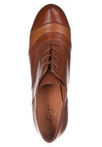 Chaussure Oxford en cuir marron avec des lacets et une bande marron plus claire sur la zone des orteils, vue de dessus sur un fond blanc.