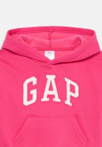 Felpa rosa brillante con tasca frontale e lettere bianche "GAP" sul petto.