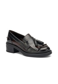 Mocasín de cuero negro con un acento de borlas, tacón bajo y acabado suave. Presenta costuras detalladas y una suela resistente.