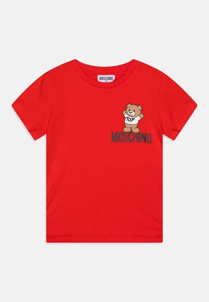 Rotes Kurzarm-T-Shirt mit Moschino-Logo und einem Cartoon-Teddybär, der ein Shirt mit der Aufschrift "Toy" trägt, auf der Brust bedruckt.