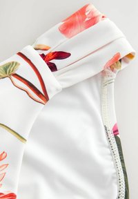 Bloemmotief zwemtop met een witte basis, geplooid ontwerp bij de halslijn en een gladde textuur met netjes gestikte randen.
