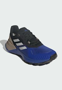 Baskets de sport bleues avec tige en maille noire, rayures blanches et accents gris. Présentent une semelle texturée pour l'adhérence et un design rembourré.