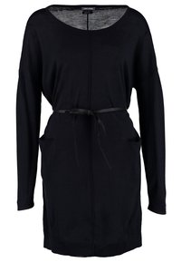 Robe noire à manches longues avec encolure ronde, poches latérales et fine ceinture noire nouée à la taille, en tissu doux.