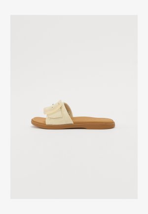 Sandália deslizante de tecido amarelo com uma única correia ajustável, palmilha acolchoada e sola de borracha castanha, apresentando um design minimalista e costura.