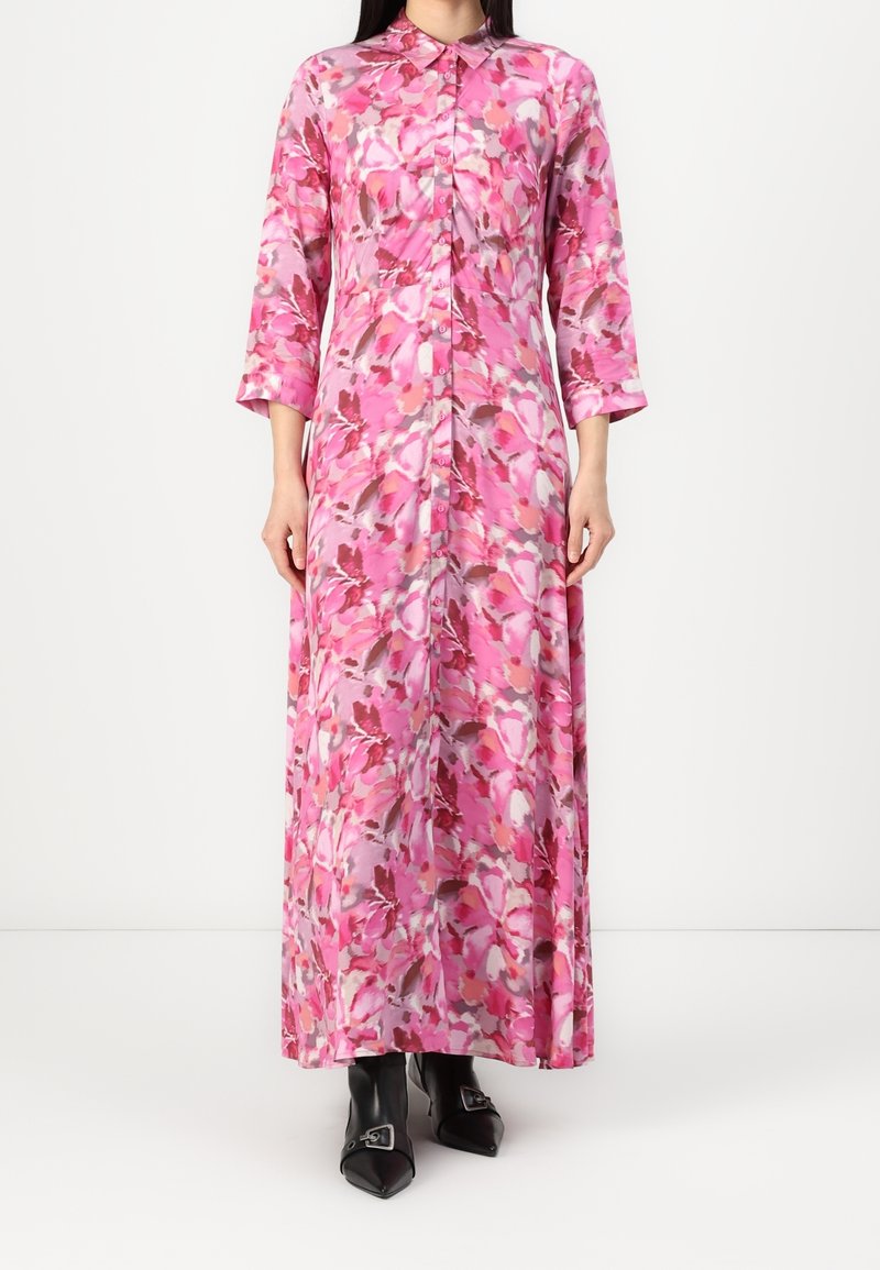 Robe longue rose à fleurs avec un col chemise, une patte de boutonnage sur le devant et des manches trois-quarts. Tissu lisse avec des motifs floraux abstraits.