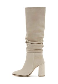 Stivali beige sopra il ginocchio con un design morbido, realizzati in suede, dotati di punta affilata e tacco largo.