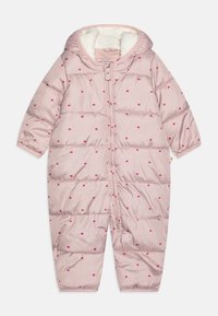 Combinaison de neige matelassée rose avec capuche, ornée de petits motifs rouges en forme de cœur, design matelassé, texture douce, et fermeture éclair à l'avant.