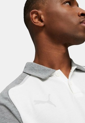 Polo shirt con un corpo bianco strutturato e spalle grigie. Presenta una chiusura a tre bottoni e un logo grigio discreto sul petto.