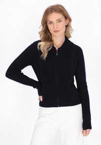 Cardigan blu navy con zip, dotato di texture a coste, ampio colletto e maniche lunghe, progettato con pannelli laterali per una vestibilità strutturata.