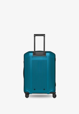 Maleta azul de carcasa rígida con asa telescópica negra extendida y cuatro ruedas giratorias negras sobre fondo blanco.