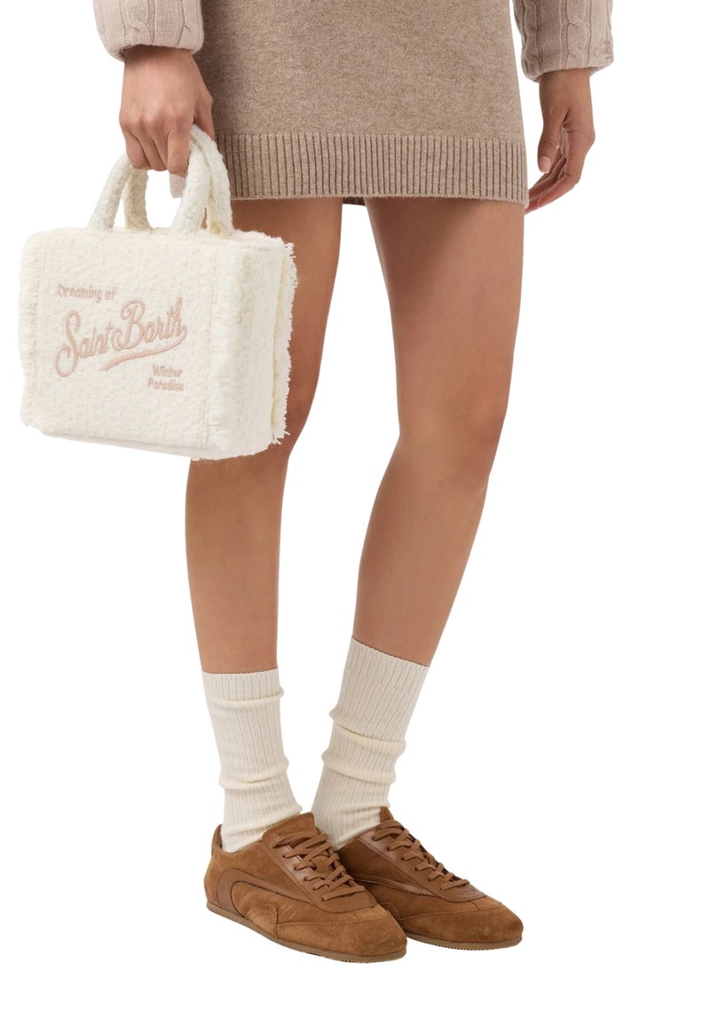 Sac à main en polaire blanche avec broderie rose, porté avec une robe en tricot beige et des baskets en daim marron, superposé avec des chaussettes à côtes crème.