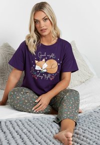 Lila kortärmad pyjatröja med en rävillustration och text; parat med grå blommiga pyjabyxor. Mjuk tyg, avslappnad passform.