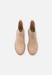 Stivali Chelsea in suede beige con pannelli elastici ai lati e linguette di trazione. Presentano una suola in gomma testurizzata e un rivestimento interno liscio. Taglia 37.