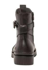 Bota negra de cuero hasta el tobillo con superficie texturizada, cremallera lateral, detalle de hebilla y suela de goma resistente.