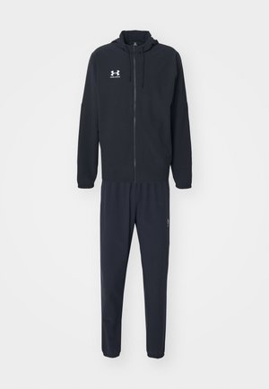 Chándal deportivo negro hecho de una tela suave; cuenta con una sudadera con cremallera y cordones, y pantalones ajustados a juego con bolsillos laterales.