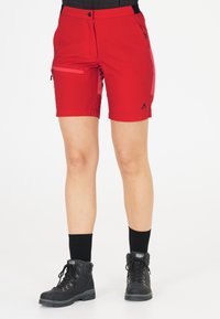 Röda utomhusshorts med en dragkedjeficka, med kontrasterande rosa detaljer, en figursydd design och ett andningsbart material. Matchad med svarta stövlar.