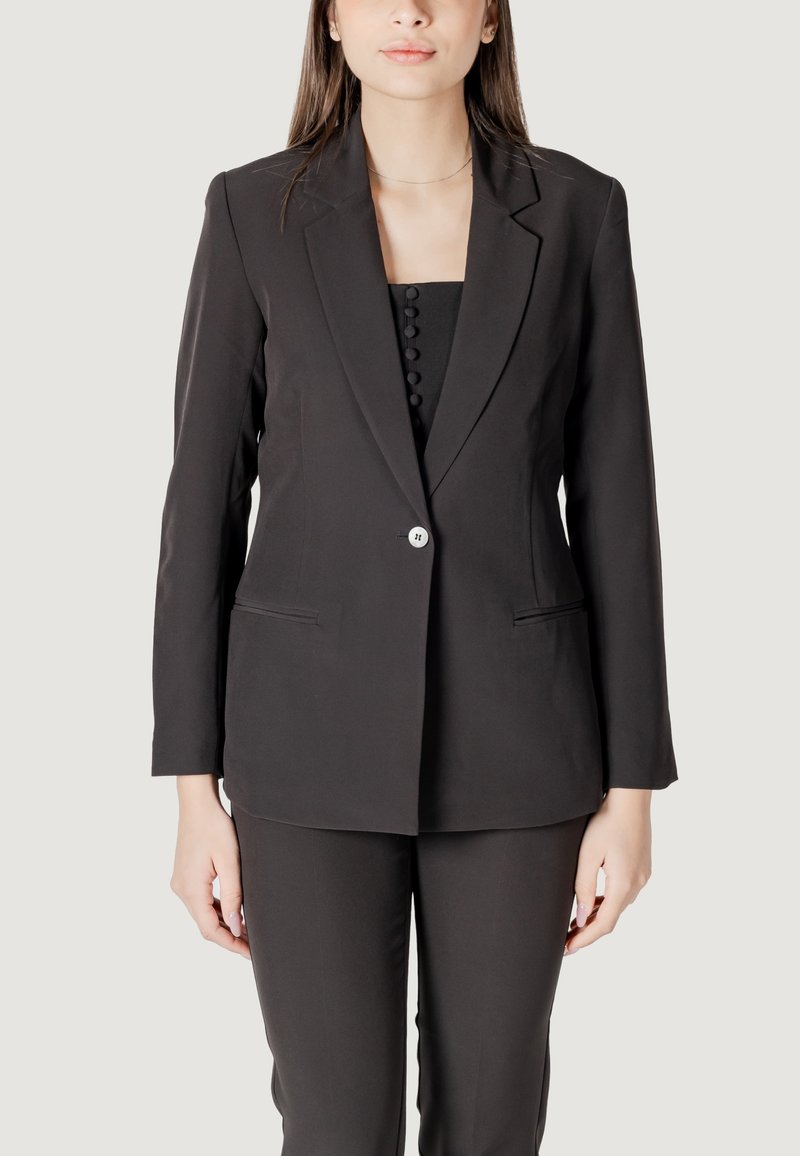 Blazer noir ajusté avec revers crantés, fermeture à un bouton et poches avant. Tissu lisse et coupe structurée. Assorti avec un pantalon coordonné.