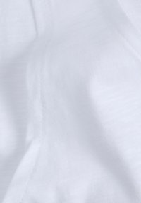 Tejido blanco con una textura suave y un sutil ribete horizontal. El material parece ligero y transpirable, con un caído suave.