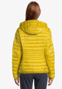 Gul puffjacka med huva, med quiltad textur och horisontella sömmar. Slät, glänsande material med en åtsittande silhuett.