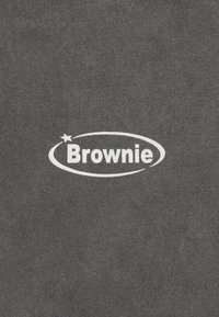 Tela de algodón gris con un logo circular blanco que lleva el texto "Brownie" y un pequeño acento de estrella.