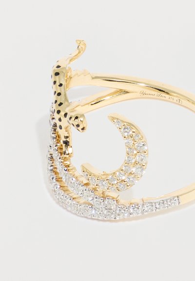 Χρυσό δαχτυλίδι με υφή και διακοσμητικό λεοπάρ, καθώς και καμπυλωτές ταινίες στολισμένες με διάφανα κρύσταλλα για επιπλέον λάμψη.