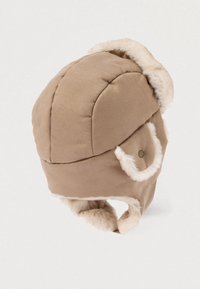 Chapeau style aviateur beige avec bordure en fausse fourrure et cache-oreilles, fabriqué en tissu doux, présentant une forme arrondie et des boutons en décoration.