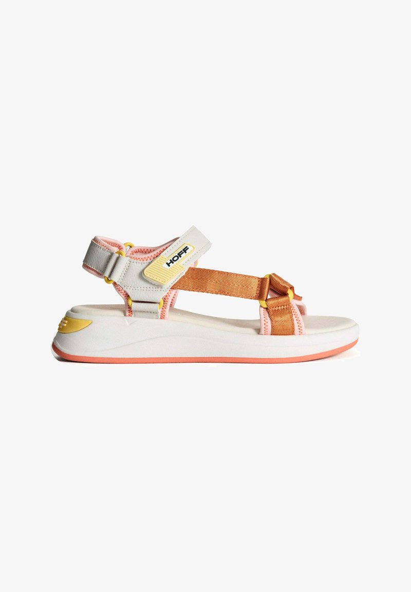 Sandales avec un design blanc et orange : sangles en nylon avec des accents jaunes, une semelle légèrement courbée et un contour en caoutchouc rose.