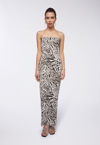 Abito lungo senza spalline con stampa zebra nei colori beige e marrone scuro. Presenta una siluetta aderente e un tessuto liscio e elasticizzato.