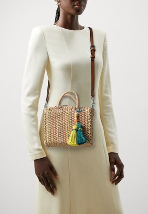Tkaná slaměná kabelka s barevnými akcenty a dvěma třásněmi v žluté a azurové. Obsahuje horní ucho a nastavitelného hnědého popruhu.