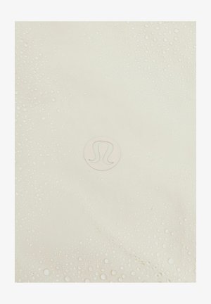 Lululemon jóga matrac világos krémszínben, texturált felülettel, kiemelkedő cseppekkel és szürkével megrázott középső logóval.