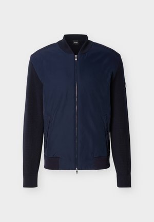 Tengerészkék bomber dzseki kötött ujjakkal, bordázott nyakkal, mandzsettával és szegéllyel, elülső cipzárral, két oldalzsebbel, valamint BOSS logóval a nyakcímkén.