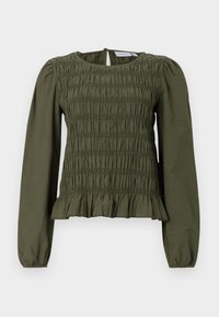Haut à manches longues vert olive avec une texture smockée et un ourlet froncé. Encolure arrondie avec une fermeture à bouton dans le dos. Fabriqué en tissu léger.